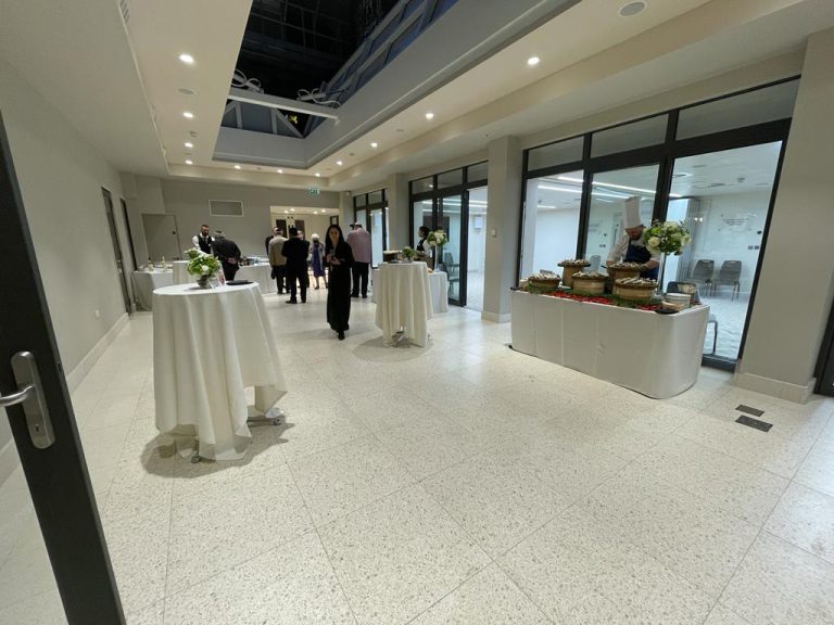 Interior space of the Atrium at The Central at night. People attending an event.